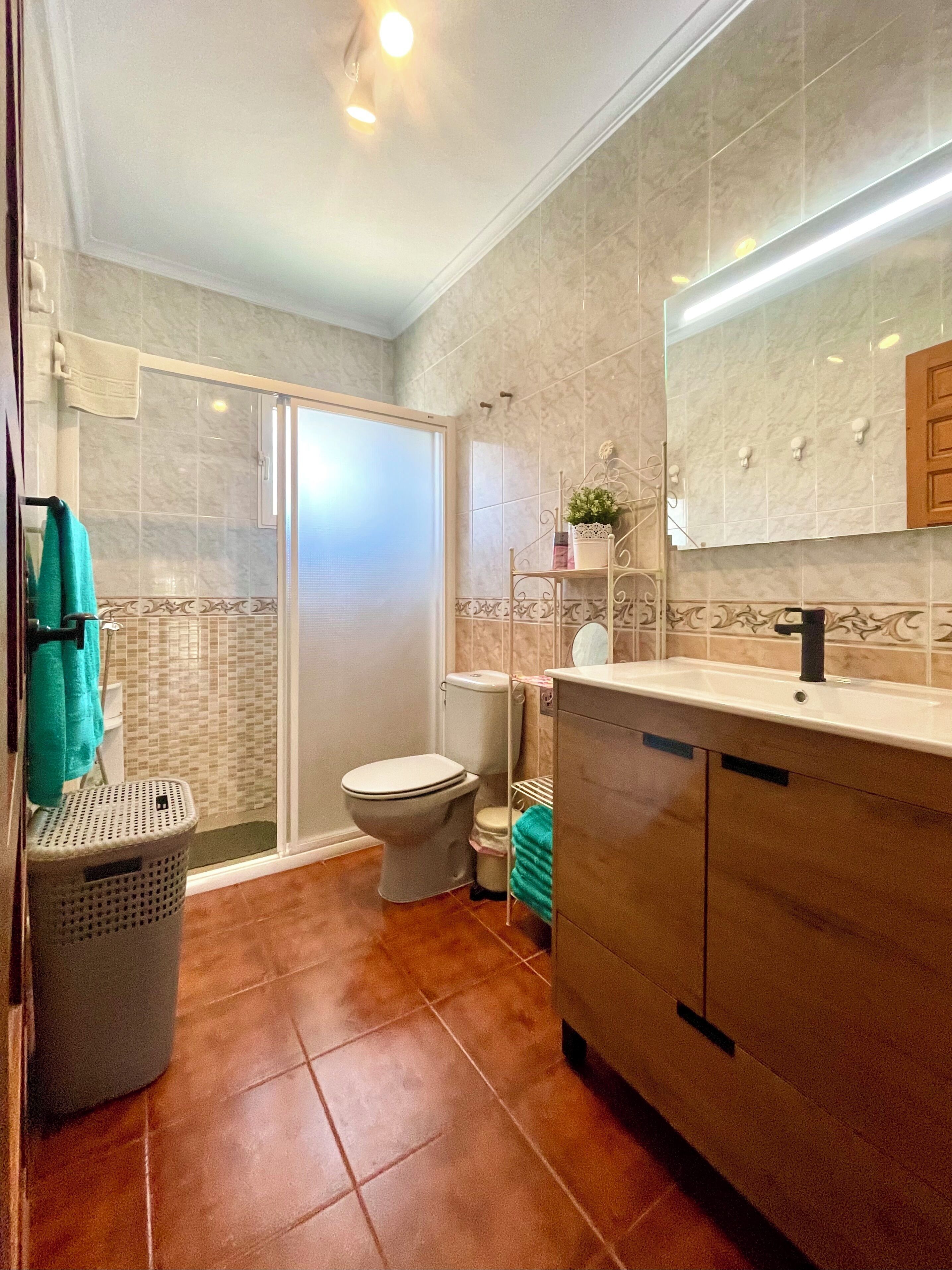 Une salle de bain avec des toilettes, une douche et un lavabo.