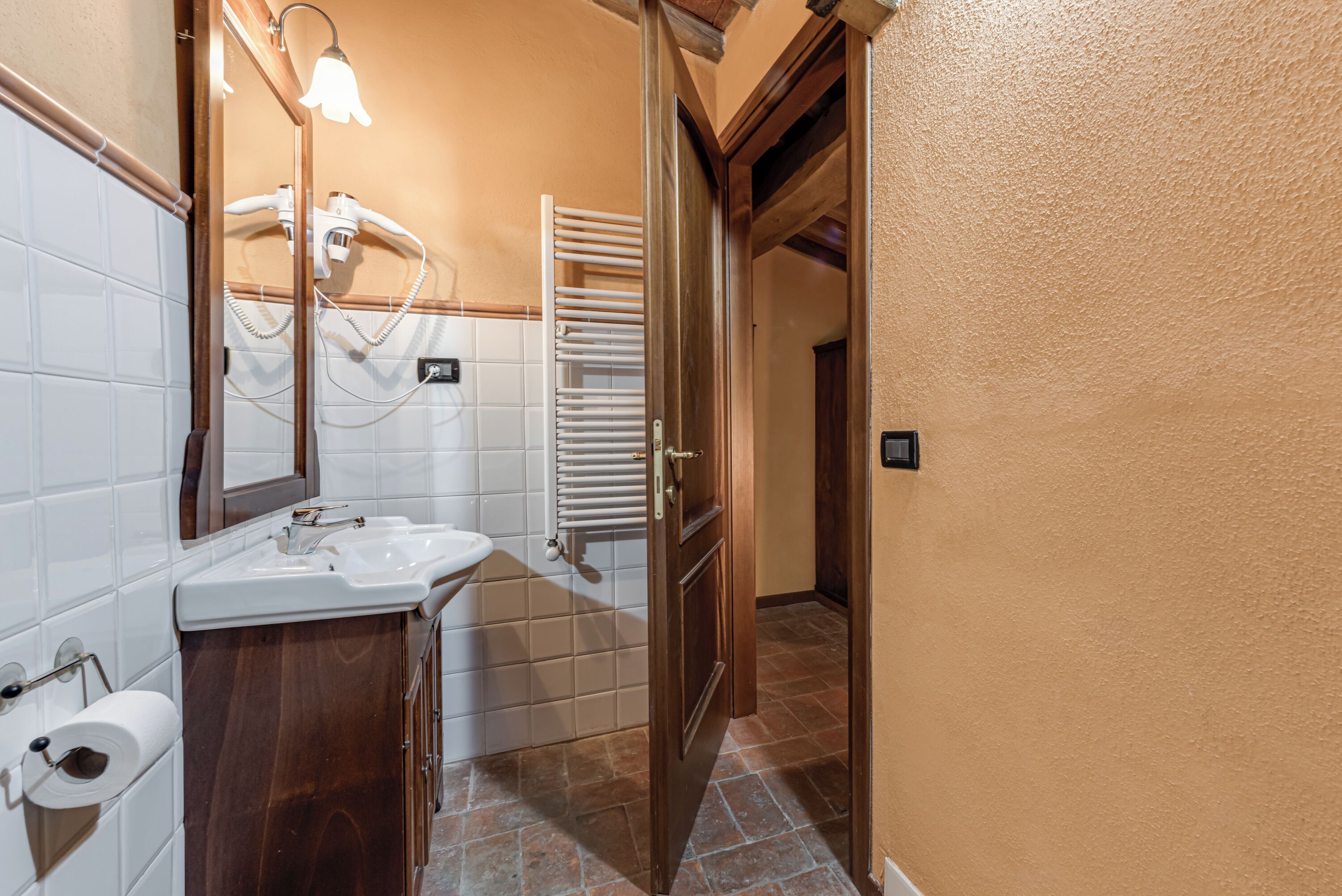 Une salle de bain équipée d’un lavabo, d’un miroir et d’un porte-serviettes.