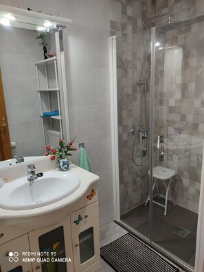 Chuveiro, secador de cabelo, toalhas de banho, sabonete