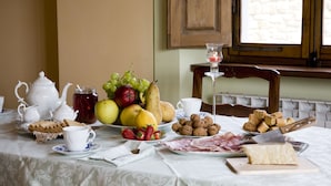 A breakfast table with tea set, fruits, bread, cheese, and a knife. - Ancient country villa with pool in the hills of Tuscany, surrounded by woods  (Poppi)