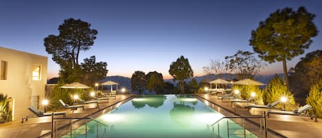 Una piscina al aire libre, sillones reclinables de piscina