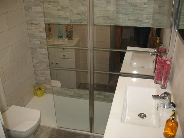 A modern bathroom with a glass shower enclosure, a toilet, a sink, and a vanity. - Apartment in private urbanization with pool and garden area in Santa Pola (Santa Pola)