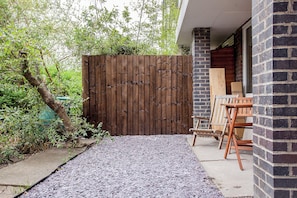 A wooden fence, a gravel pathway, and a brick building with a door. - Central 1BDR Flat in Clerkenwell (London)