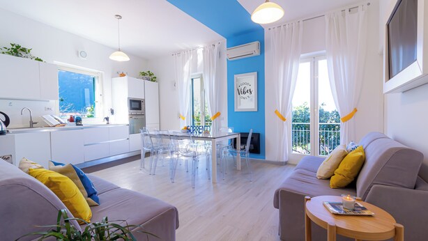 Un salon moderne comprenant un canapé, une table basse et un coin repas avec une table et des chaises.