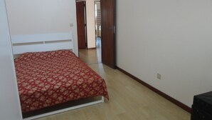 Ein Schlafzimmer mit einem Bett, einer Holztür und einem gefliesten Boden.