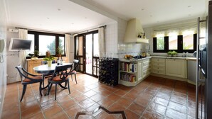 Un'ampia cucina con zona pranzo, una dispensa per vini e una libreria.