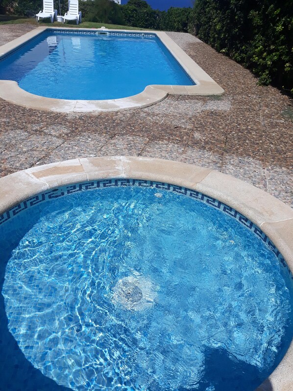 A swimming pool with a tiled edge and a pebble-patterned deck. - House in Calan Morell with garden, private pool and BBQ 300 m from the beach (ciudadela de menorca cALAN morell)