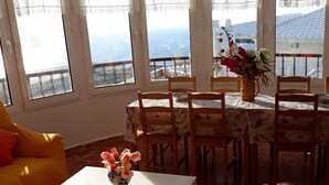 A sunlit room with a dining table and chairs, a small white table, and yellow armchairs. - House in Calan Morell with garden, private pool and BBQ 300 m from the beach (ciudadela de menorca cALAN morell)