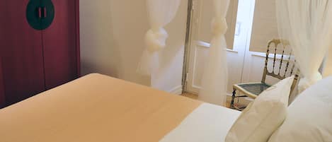 Ein Schlafzimmer mit einem Bett, einem Sessel und einem Kleiderschrank.