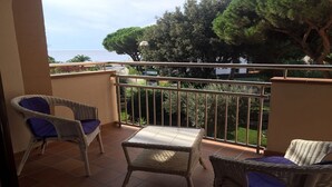 A balcony with wicker furniture and a view of the sea. - APARTMENT NEXT TO THE SEA WITH COMMUNITY GARDEN AND PLAZA PARKING WITH FREE WIFI (Platja d'Aro)