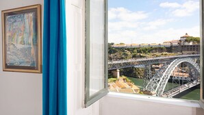 Una habitación con un ventanal que da a un puente y un río.