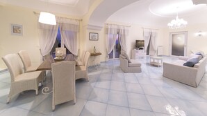 A spacious living area with a dining table, wicker chairs, a sofa, and a TV. - Luxury villa with panoramic swimming pool in Ischia, near Amalfi Coast (Forio)
