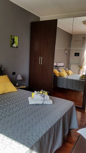 A hotel room with a large bed, a wardrobe, a nightstand, and a mirror. - SUNFLOWER HOUSE RIPAMONTI IEO (CIR: 015146-CNI-00874) (Milano)