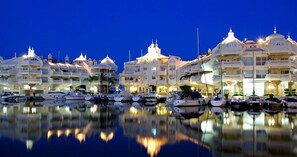 A marina with yachts docked in front of a hotel with multiple domed structures.