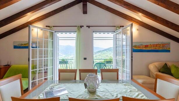 A dining area with a glass table, wooden chairs, and a view of the outdoors. - Ca du Pescou, Rapallo (Rapallo)