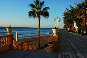 Stroll along the promenade, lined with palm trees and decorative lamp posts, to the beach.