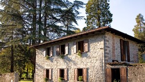 A stone building with multiple windows, some with shutters, and a tiled roof. - CASETTA green park, equipped, near center village OPTIONAL HOT TUB exclusive use (Pratovecchio)