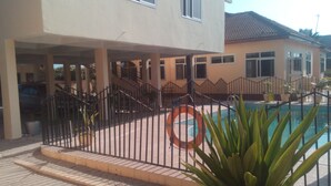 A two-story house with a swimming pool, a covered patio, and a staircase leading to the upper floor. - Chic One bedroom serviced  apartment with  pool- fully self contained  V6 (Accra)