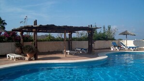A clear blue swimming pool with lounge chairs and a pergola structure. - 2 Bed Det.Villa in La Manga Club.  5g Wi-Fi, Pool, A/C  winter monthly discounts (Los Belones)