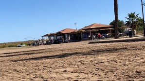 A beachside area with thatched-roof huts and palm trees. - 2 Bed Det.Villa in La Manga Club.  5g Wi-Fi, Pool, A/C  winter monthly discounts (Los Belones)