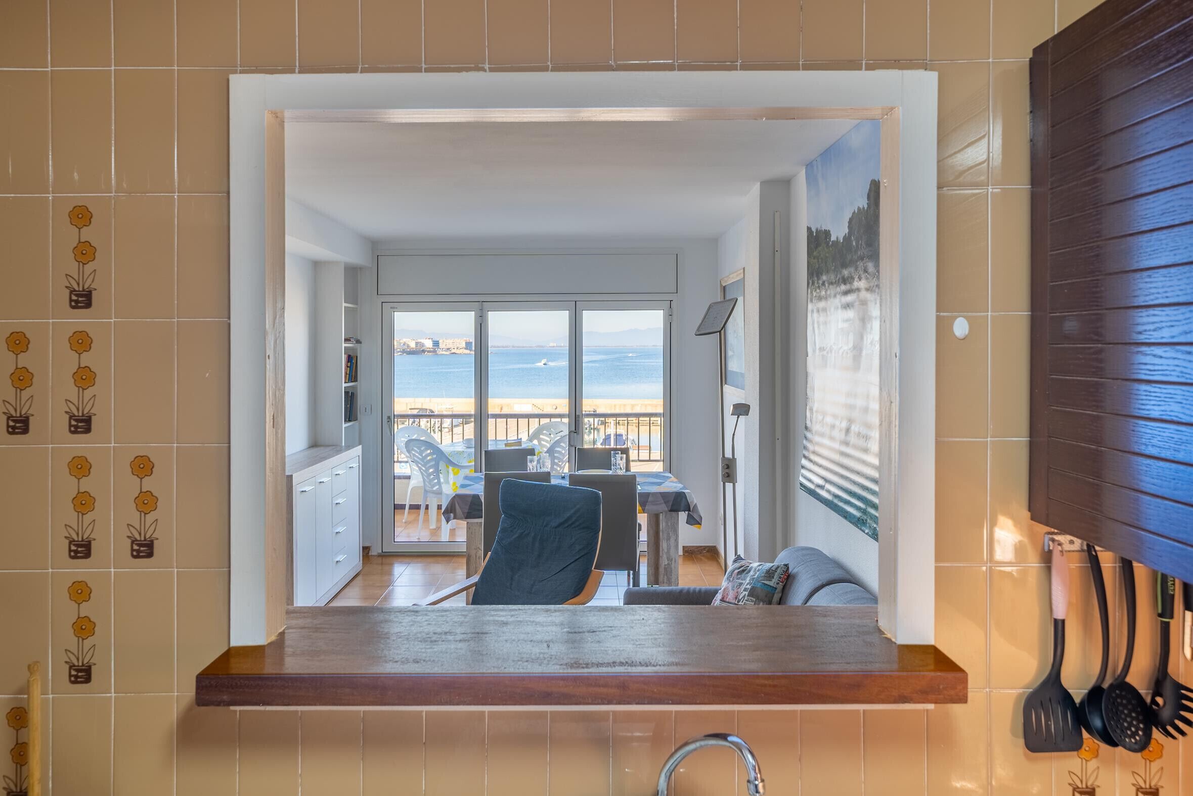 Eine Küche mit Blick auf einen Essbereich und einen Balkon mit Meerblick.