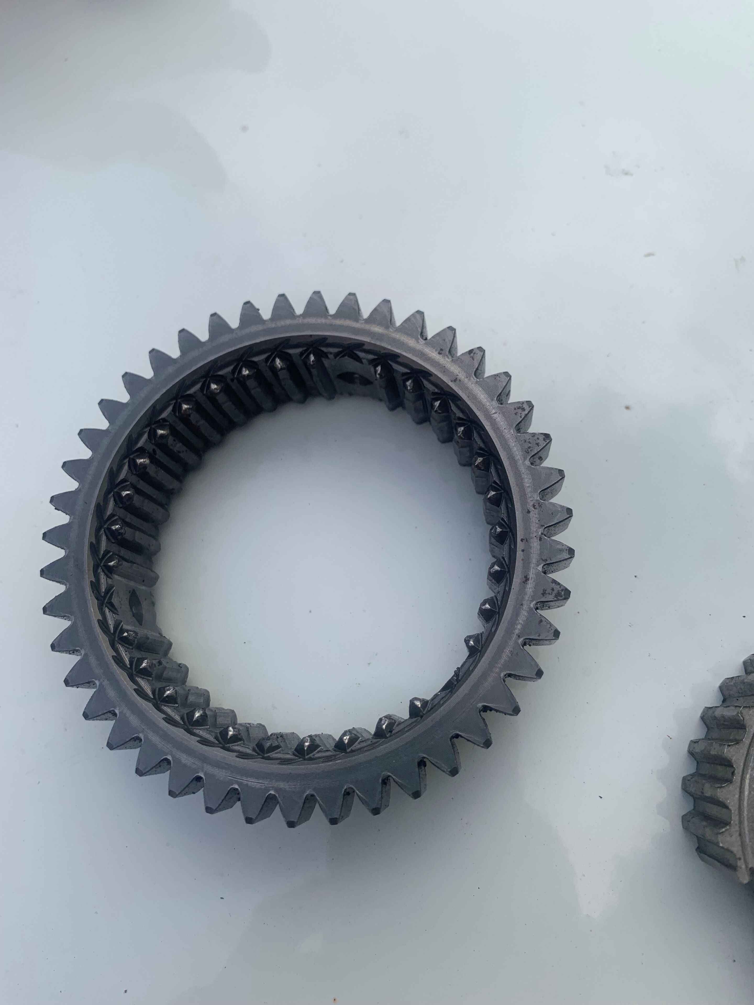 Ein metallisches Zahnrad liegt auf einer ebenen Fläche.
