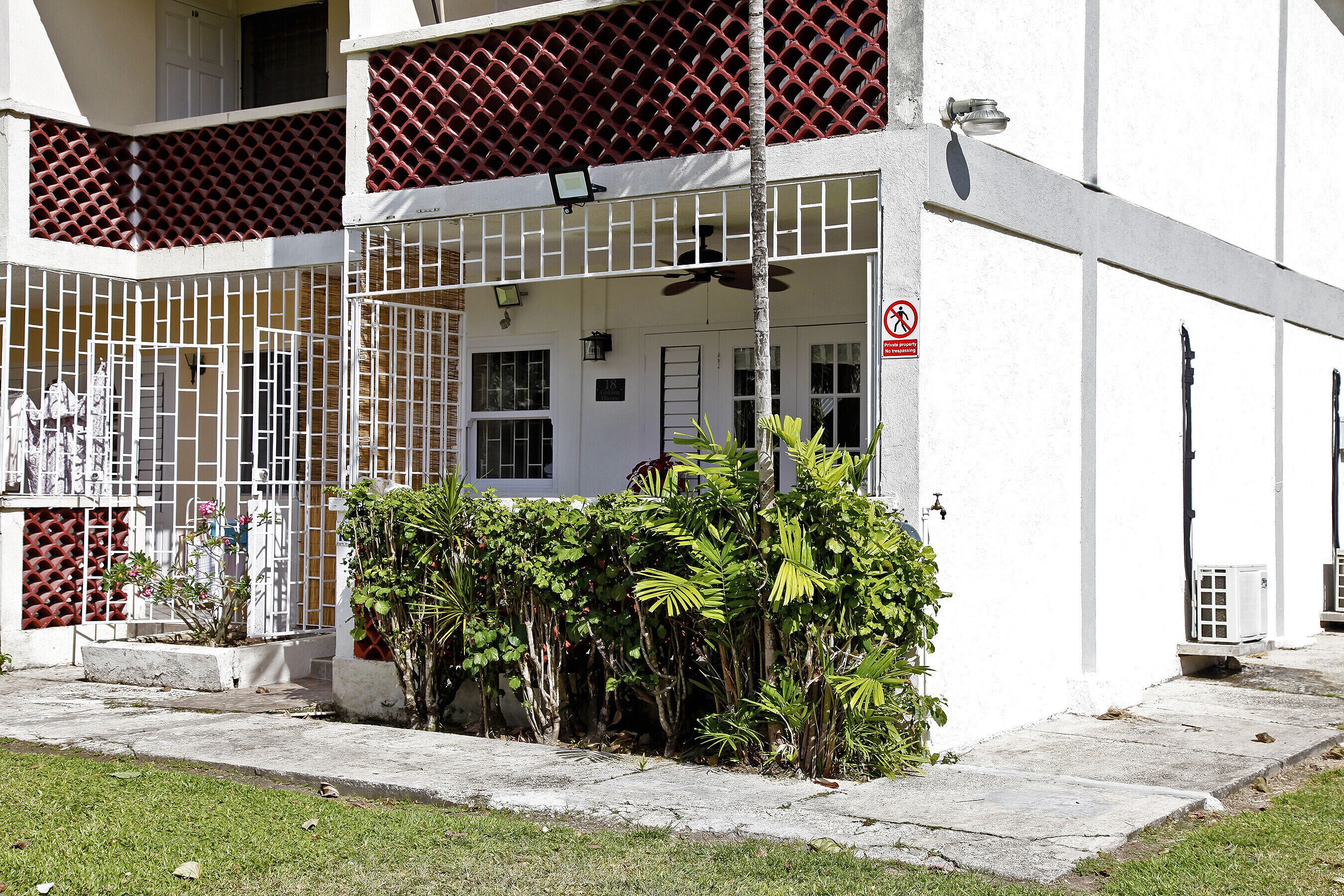 A building with a gated entrance, a sign indicating private property, and a number 18 on the door.