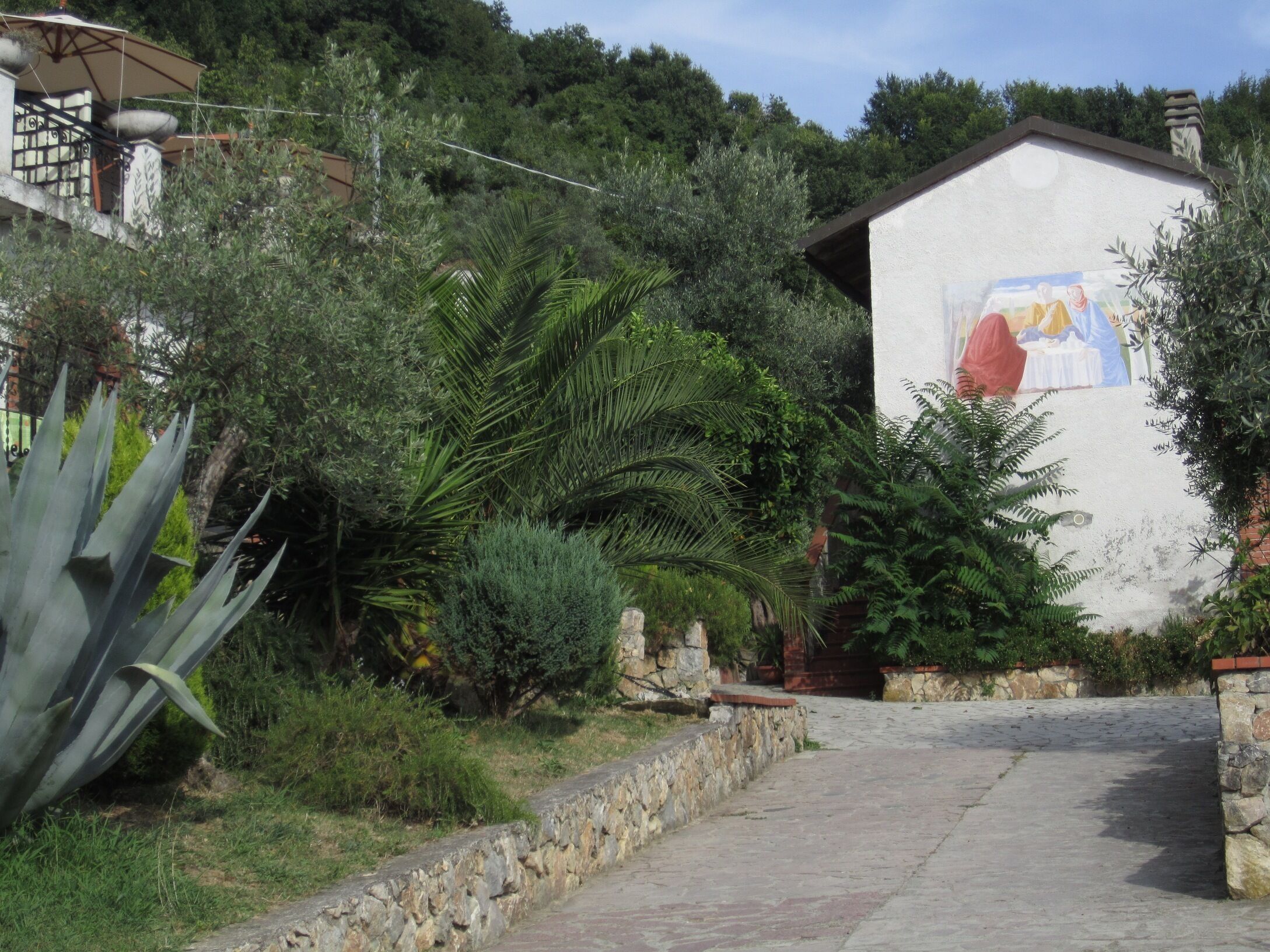 Un sendero de piedra que lleva a un edificio con un mural.