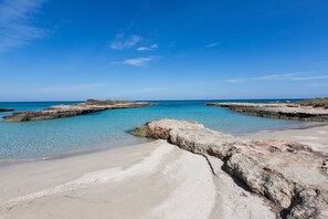 A beach with clear turquoise water, rocky formations, and a sandy shore. - Villa Irene - Large garden - Privacy - Big terrace - 400 m from the beach  (Carovigno)