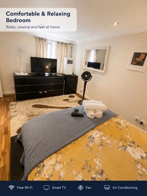 A bedroom with a bed, a TV, a fan, and an air conditioning unit. - The Kensington Lovely Elegant Executive Residence (London)