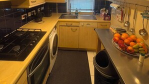 Una cocina compacta con estufa, lavamanos y un ventanal.