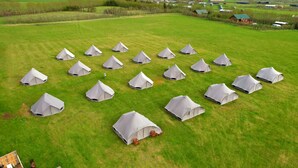 A large open field with multiple conical tents arranged in a grid pattern. - Godaland Guesthouse (Rangárþing eystra)