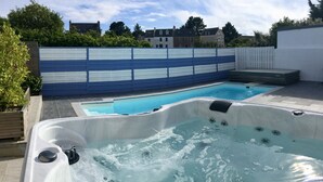A swimming pool with a hot tub in a backyard setting. - Villa Métisse with neat decoration and great comfort (Groix)