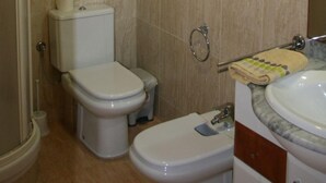 Un baño con inodoro, bidé y lavamanos.
