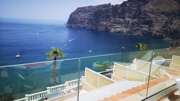 Ein Balkon mit freiem Blick auf das Meer und eine felsige Klippe.