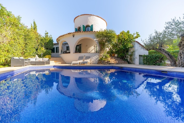 A swimming pool with a white building in the background.
