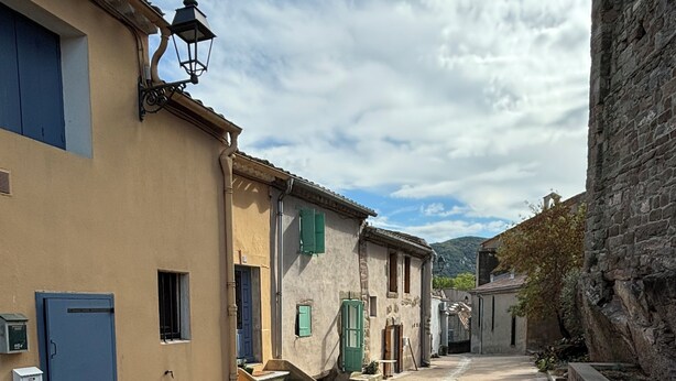 A narrow street with buildings on either side, featuring stone steps and a blue door. - Charming, centrally located house close to Carcassonne, perfect for families! (Capendu)