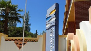 Skilt for Boca do Rio med klar himmel og palmer i baggrunden.