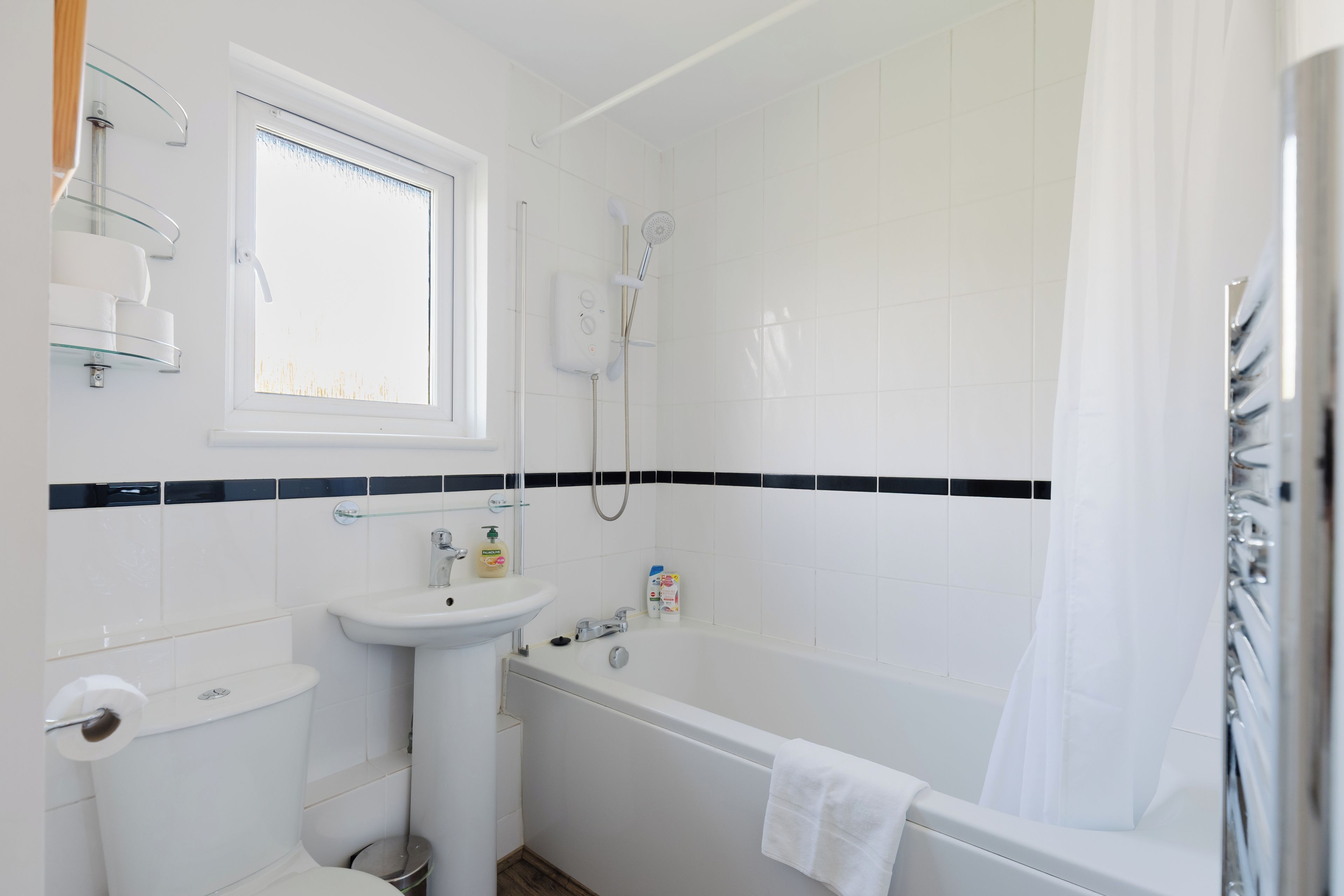 A bathroom with a toilet, sink, and bathtub.