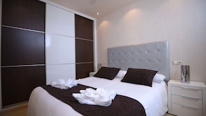 Une chambre d’hôtel moderne avec un grand lit, une armoire et une table de chevet.