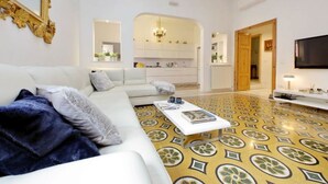 Una sala moderna con un sofá blanco, una mesita de centro y un suelo con estampado.