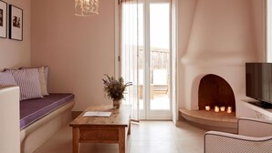 Un salon confortable avec un canapé, une table en bois, une cheminée et un téléviseur.