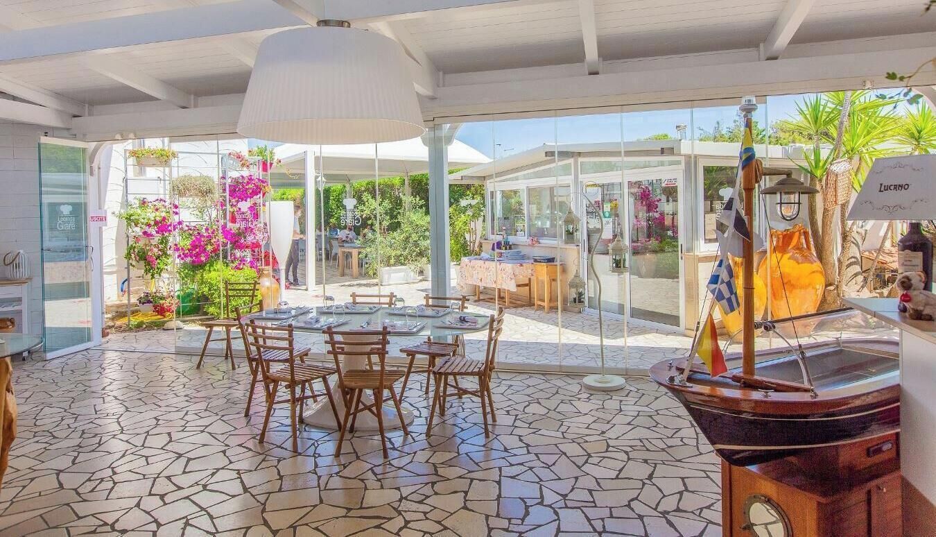 A restaurant with outdoor seating, a tiled floor, and a large window.