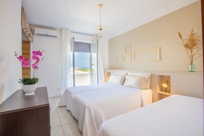A hotel room with two beds, a large window with a view, a plant on a bedside table, and a wall-mounted light fixture. - Villa Salento. 250 m from the beach, sea view, 500 M of FENCED GARDEN. WOW (Carovigno)
