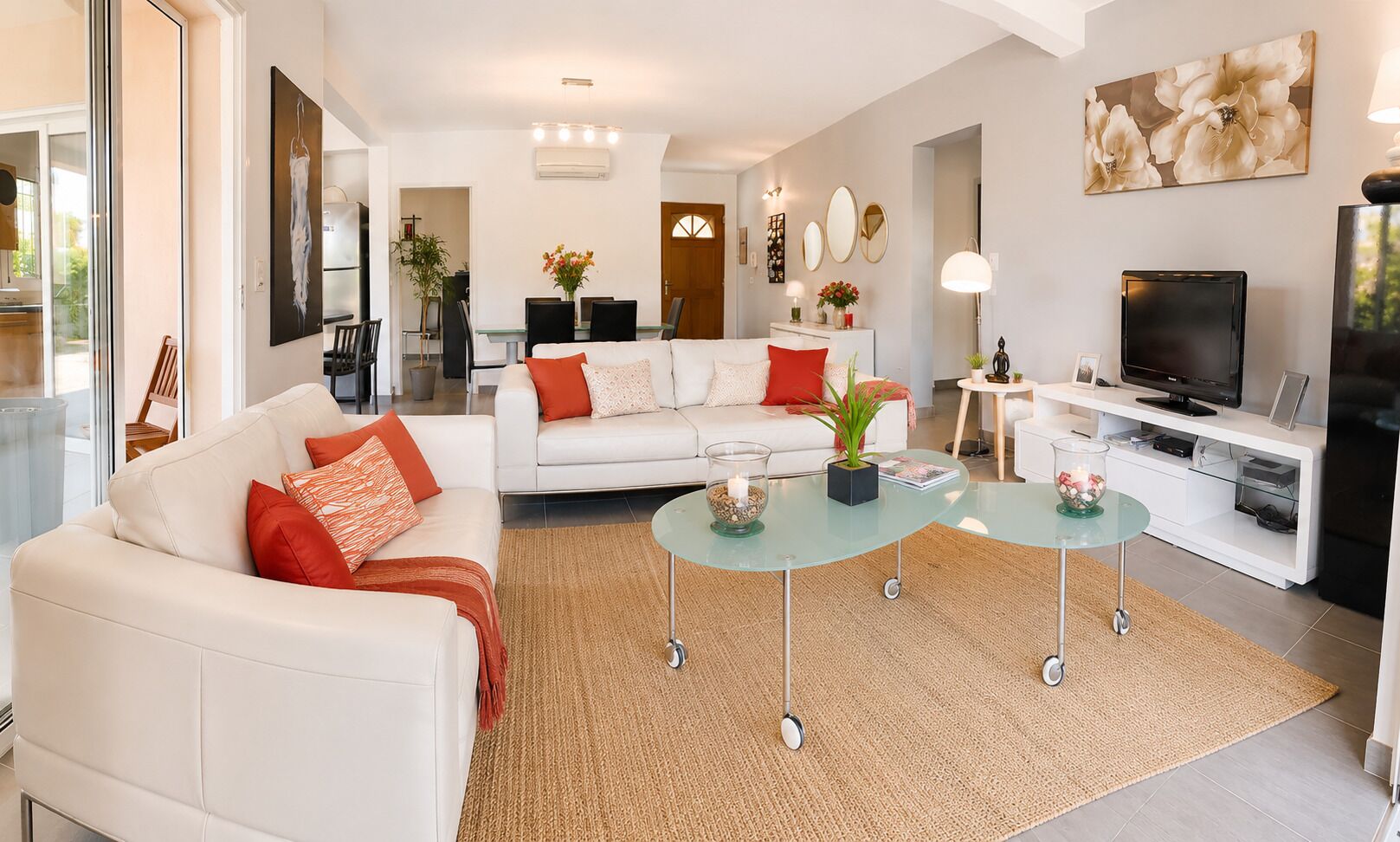 A modern living room with a sofa, coffee table, TV, and artwork.