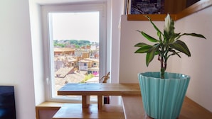 Quarto com mesa de madeira e planta em vaso.