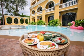A breakfast buffet with various dishes and a pool in the background. - ROYAL PINEAPPLE HOTEL | A Welcome to Wealth and Good Fortune (Krabi)