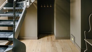 Eine moderne Treppe mit Metallgeländern, die zu einem Holzboden führt.