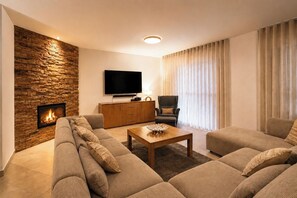 Smart-tv, eldstad, ett bordtennisbord och en stereo