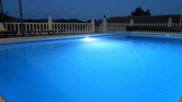 Een verwarmd zwembad, ligstoelen bij het zwembad